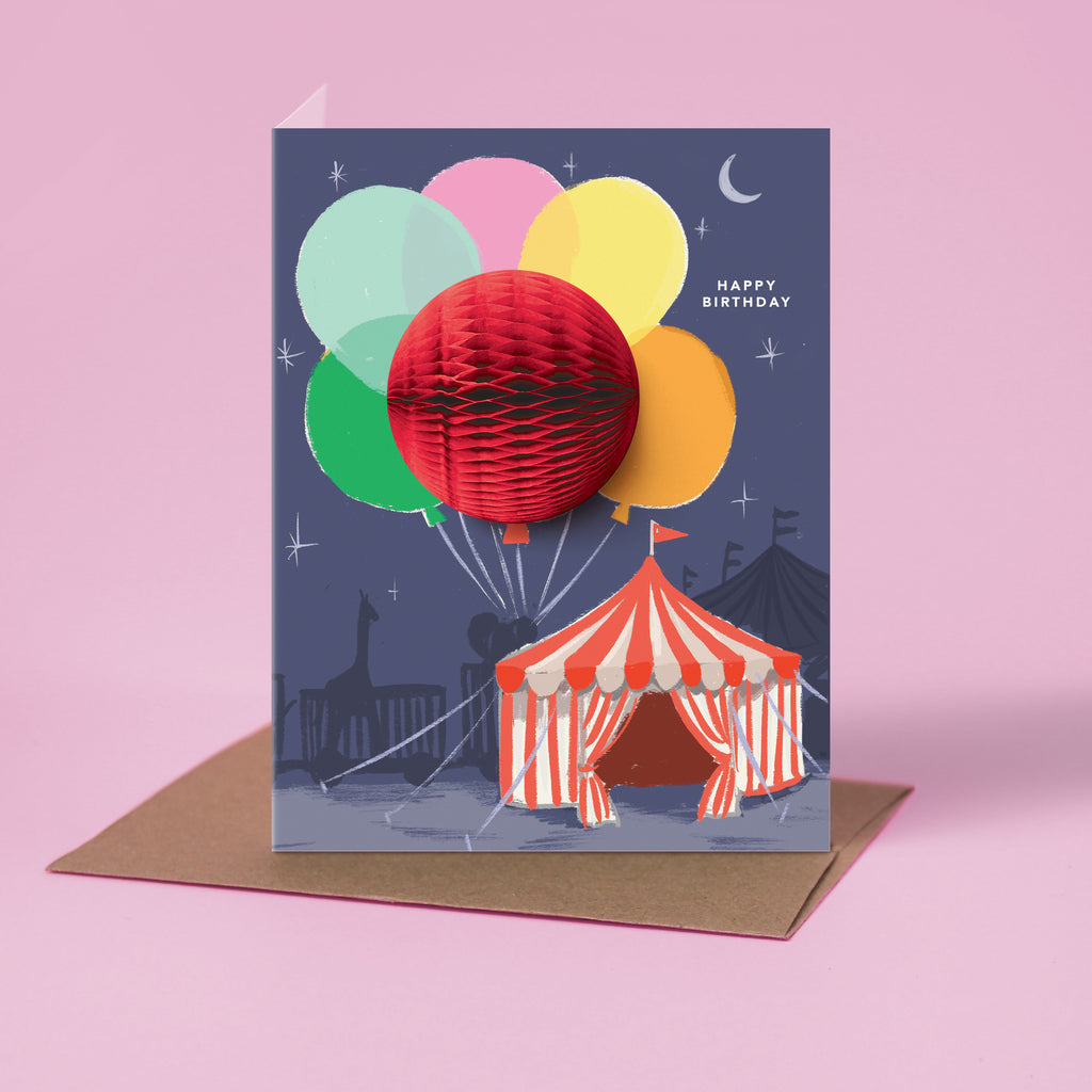 Big Top circus-themed pop-up birthday card with honeycomb balloon and a "Happy Birthday" message on the front against a purple background