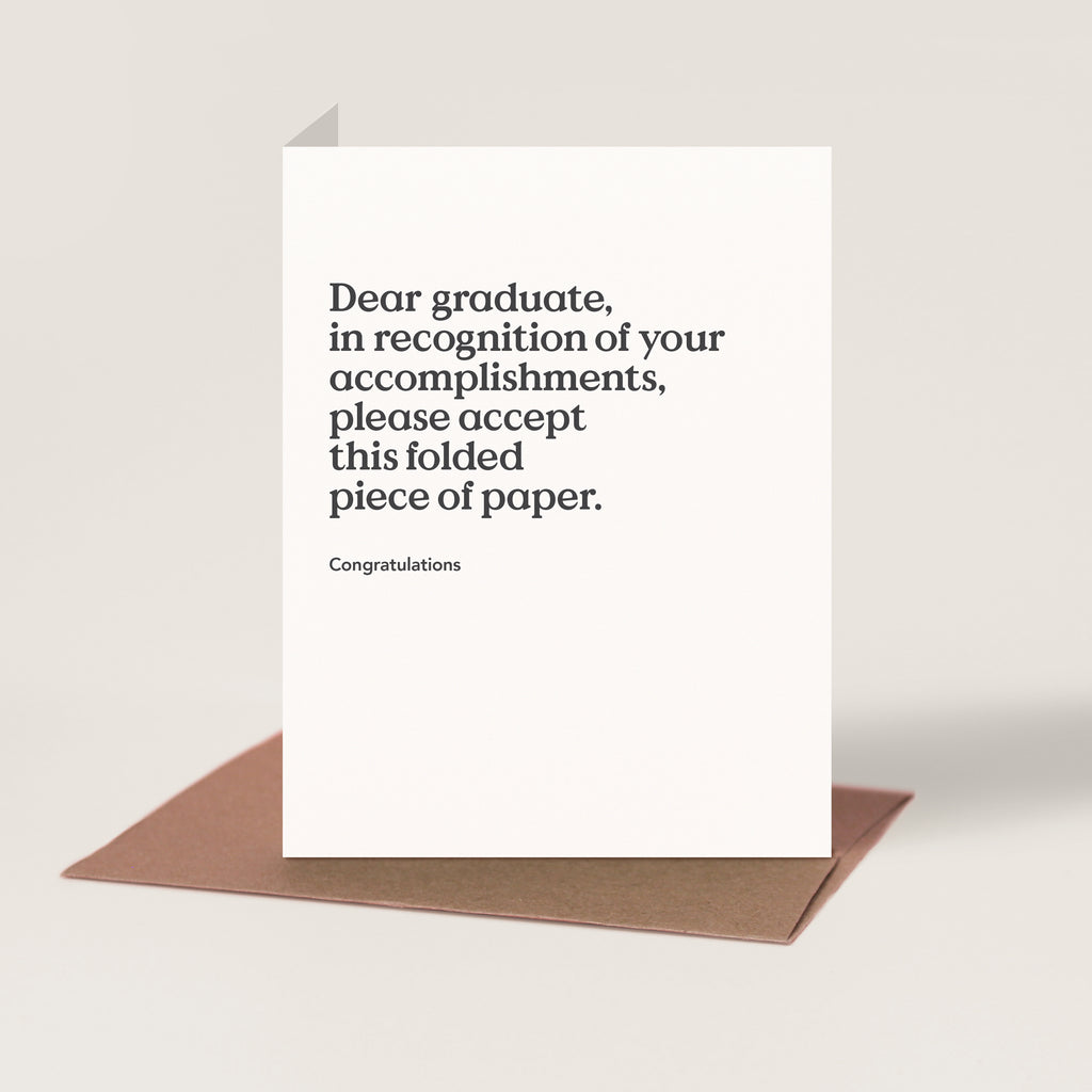 Greeting card with the following caption: "Dear graduate, in recognition of your accomplishments, please accept this folded piece of paper. Congratulations."