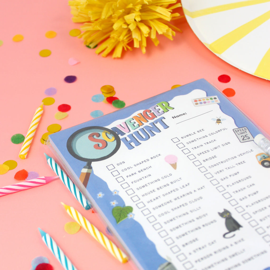 Close-up of Inklings Tiny Town Scavenger Hunt play notepad at a birthday party with confetti and candles on the table
