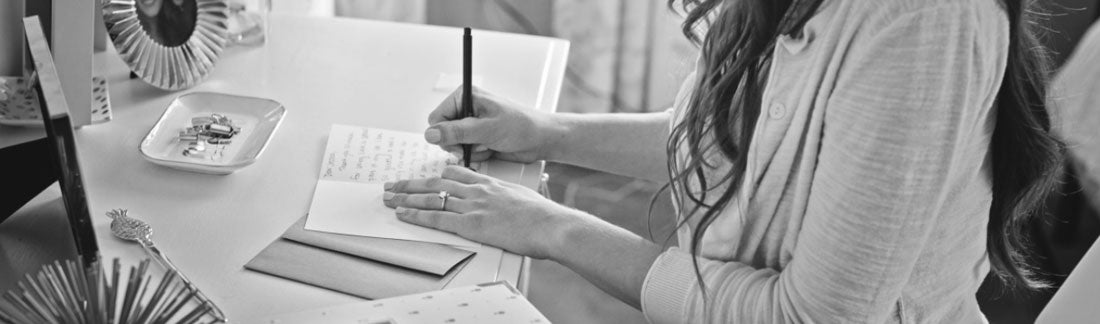 woman writing a note at her desk
